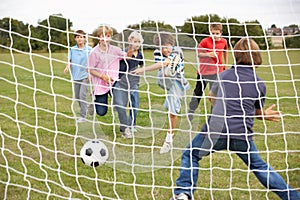 Boys playing soccer in park