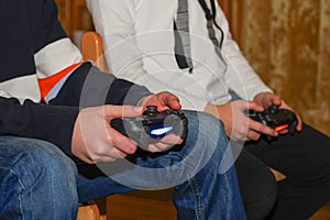 Boys are playing Sony PlayStation. Boy playing with a joystick. A boy enjoy playing game on Sony PlayStation at home. Hand boy