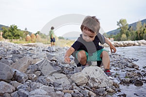 Boys playing and throwing rocks at the river