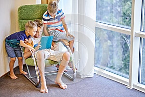 Boys siblings spend time playing games on tablet together