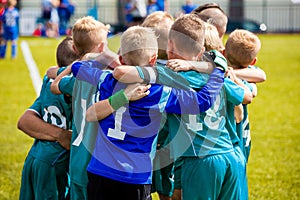 Boys` sports team huddling. Children playing sports in a team. Team sports for kids. Children sports football soccer team