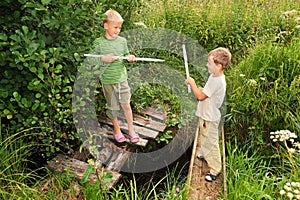 Boys with sticks battling for fun on bridges