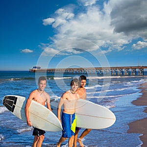 Boys surfers group coming out from beach