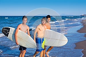 Boys surfers group coming out from beach