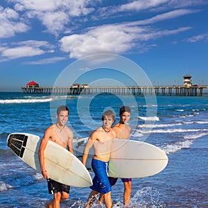 Boys surfers group coming out from beach