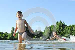 Boys swimming in the lake.