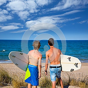 Boys teen surfers rear view looking at beach