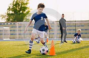 Boys training football dribbling in a field. Kids Running the Ball. Players develop soccer dribbling skills