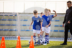 Boys Training Football on Pitch Witch Youth Coach. Group of Young School Age Boys On Training Session With Youth Coach