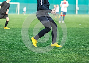 Boys in white black sportswear running on soccer field. Young footballers dribble and kick football ball in game. Training,