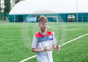 Boys in white and blue sportswear plays  football on field, dribbles ball. Young soccer players with ball on green grass. Training photo