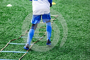 Boys in white white sportswear running on soccer field. Young footballers dribble . Training, active lifestyle, sport,