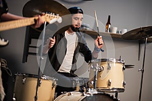 A boysband of guitarist, bassist, and drummer rehearse in their garage.