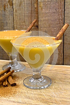 Boza and cinnamon sticks, traditional Turkish cuisine drinks, on wooden background