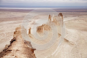 Bozzhyra tract in Kazakhstan, a scenic and arid desert landscape featuring dramatic rock formations and sediment layers