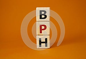 BPH - Benign Prostatic Hyperplasia symbol. Wooden cubes with word BPH. Beautiful orange background. Medical and BPH concept. Copy