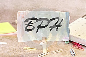 BPH Benign Prostatic Hyperplasia text on a piece of paper on the table with a clothespin clamped