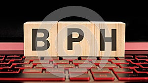 BPH Benign Prostatic Hyperplasia written on wooden cubes on the laptop keyboard