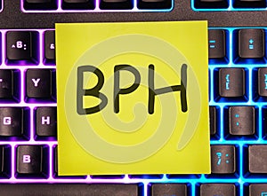 BPH BPH Benign Prostatic Hyperplasia written on a yellow sticker on a laptop keyboard with backlight