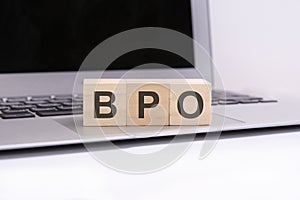 bpo - wooden cubes with letters on a laptop keyboard