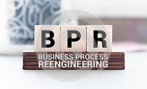 BPR - Business process reengineering - acronym on wooden cubes on columns of numbers background