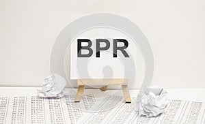 BPR - Business process reengineering - acronym on wooden cubes on columns of numbers background. BPR , acronym on wooden cubes.