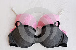 Bra pink sporty and gray with lace on white wooden background