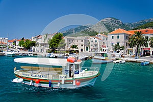 Brac, Croatia - May 17, 2016: Colourful Taxi boat in water of Marina Bol port of Pain in front of olt town