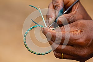 A bracelet being crafted by a Ugandan woman