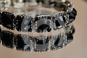 Bracelet with black stones on a glass table