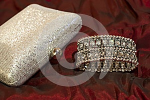 Bracelet with clear stones and shiny silver clutch bag. Stylish accessories. Jewelry for evening dress.