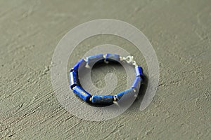 Bracelet made of natural stones. Blue stone lapis lazuli. Handmade jewelry. Handmade bracelets on a black modern background