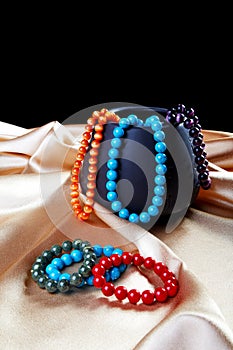 Bracelets and beads on a golden fabric