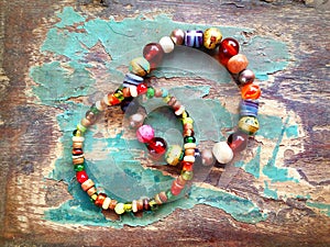 Bracelets with colorful beads on the old wooden table