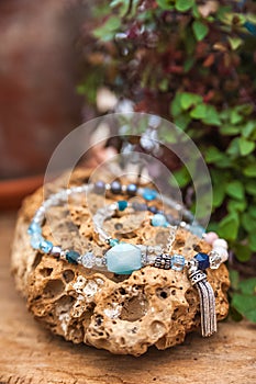 Bracelets made of natural stones on textured stones. The mysticism of amulets. Esoterics in handmade bracelets close-up and copy s photo