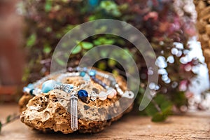 Bracelets made of natural stones on textured stones. The mysticism of amulets. Esoterics in handmade bracelets close-up and copy s