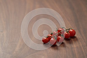 bracnh of fresh cherry tomatoes of wood table