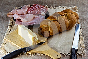 Trenza de pan aperitivo de salchichas a queso cuchillos sobre el mesa rural Manteles 