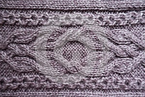 Braid pattern on puce knitted fabric photo