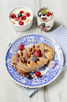 Braided danish bun made of puff pastry decorated with fresh fruits photo