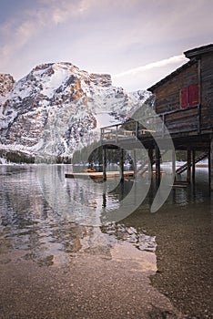 Braies lake and Dolomite with snow, palafitte harbor at sunset photo