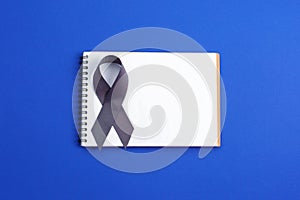 Brain cancer grey color awareness ribbon isolated on blue background