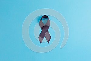 Brain cancer grey color awareness ribbon isolated on blue background photo