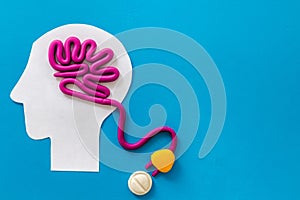 Brain charging and mental rest. Plug and cable leads to plastiline meanders on blue background top view copy space