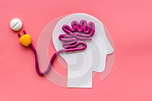 Brain charging and mental rest. Plug and cable leads to plastiline meanders on pink background top view