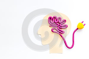 Brain charging and mental rest. Plug and cable leads to plastiline meanders on white background top view copy space