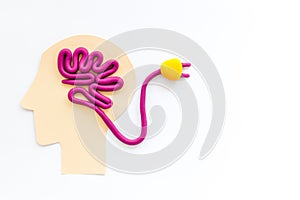 Brain charging and mental rest. Plug and cable leads to plastiline meanders on white background top view copy space