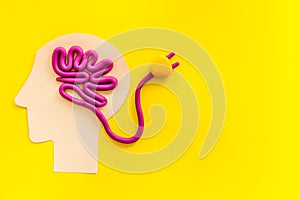 Brain charging and mental rest. Plug and cable leads to plastiline meanders on yellow background top view copy space