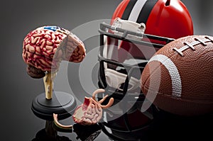 Brain damage and sports injury concept with damaged brain model, american football helmet and a ball, illustrating CTE Chronic