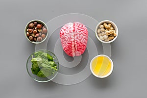 Brain food concept with peanut, hazelnut, seed-oil, spinage on gray background top view